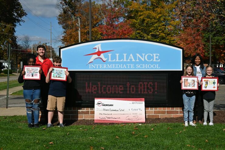 Students gathered, holding up their winning calendar submissions.