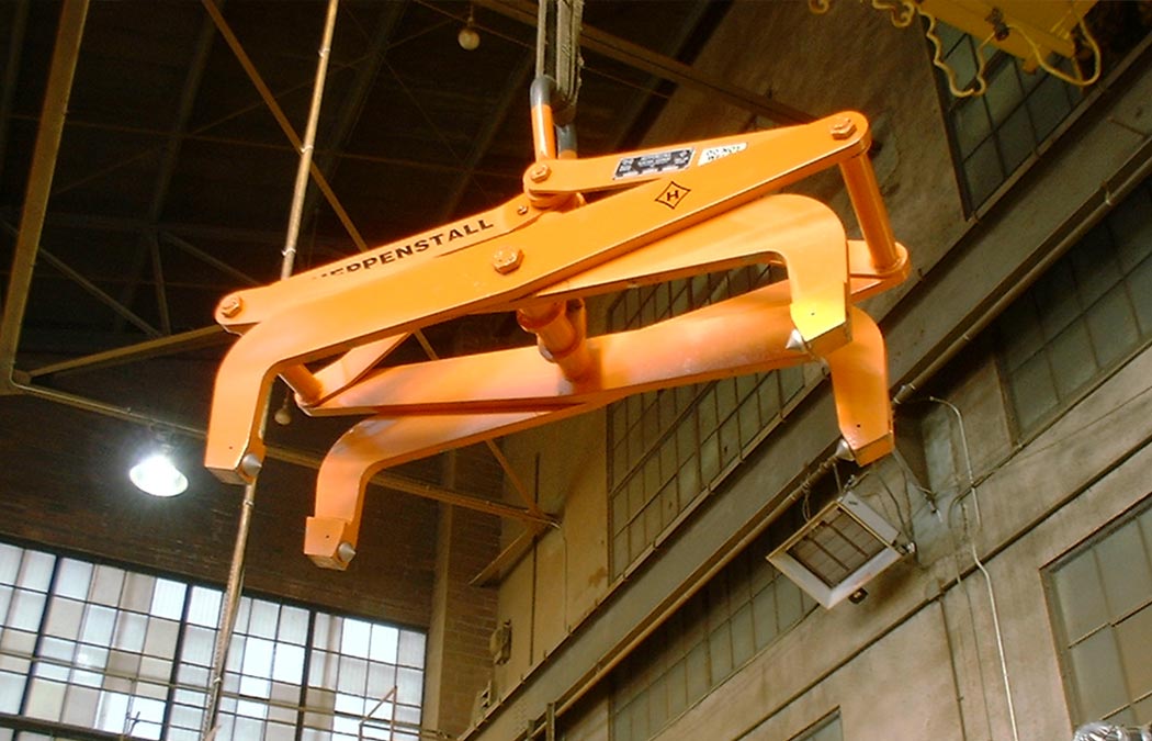 orange Heppenstall overhead crane slab tong in a factory